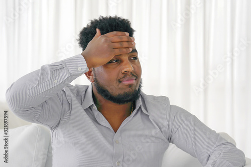 African american, arabian man suffering from headache desperate and stressed because pain and migraine. Hand on head. Negative emotion expression.