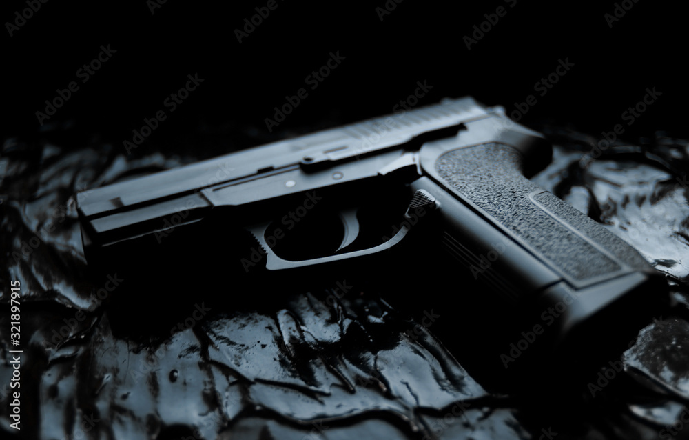 gun lies on a dark texture background close-up Stock Photo | Adobe Stock