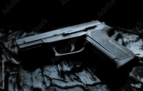 gun lies on a dark texture background close-up