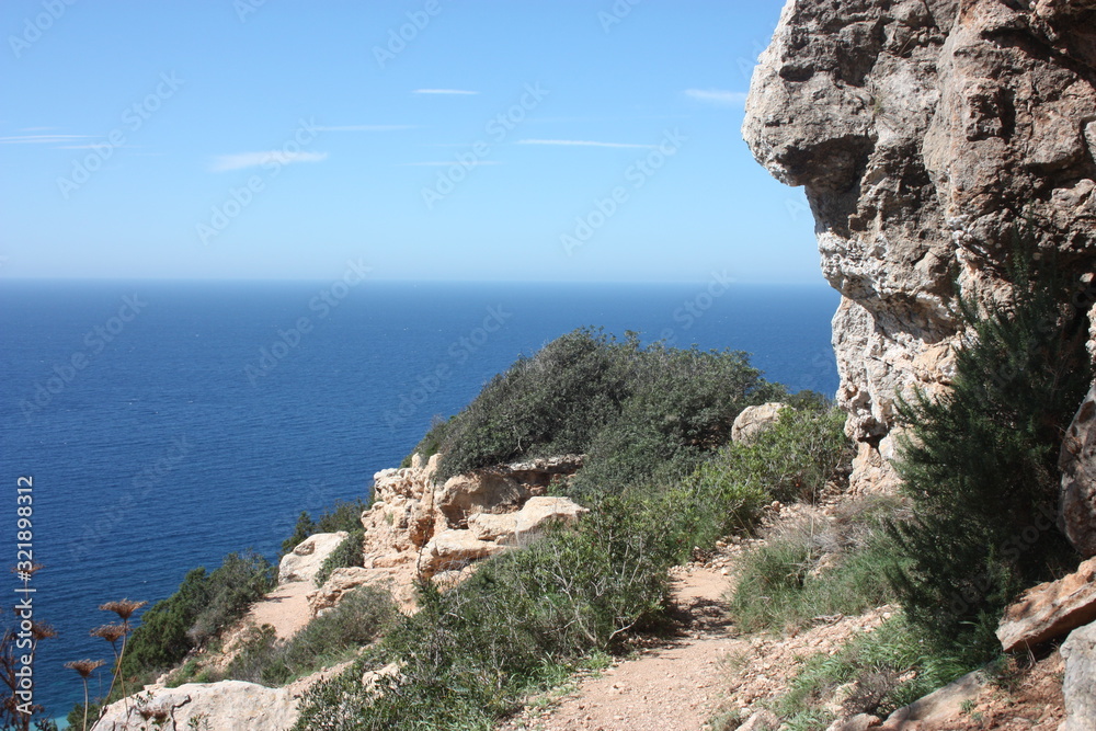 panorama on the sea of ​​Cala D'Hort among the rocky, rocky and arid cliffs in front of the almost Caribbean blue Ibizan sea