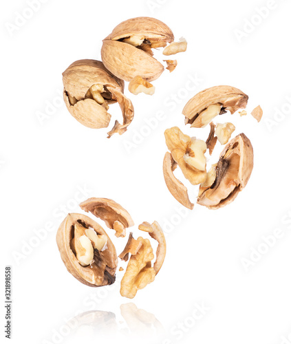 Group of crushed walnuts in the air close-up on a white background