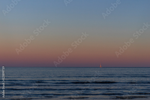 Dawn over the sea. Blue water, purple sky. © Serhii