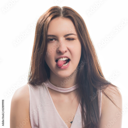 young brunet woman teasing portrait with tongue out tisolated on white background