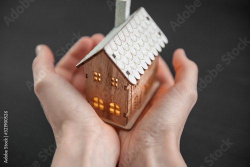 concept technology protection of the house from the cold. house in caring female hands