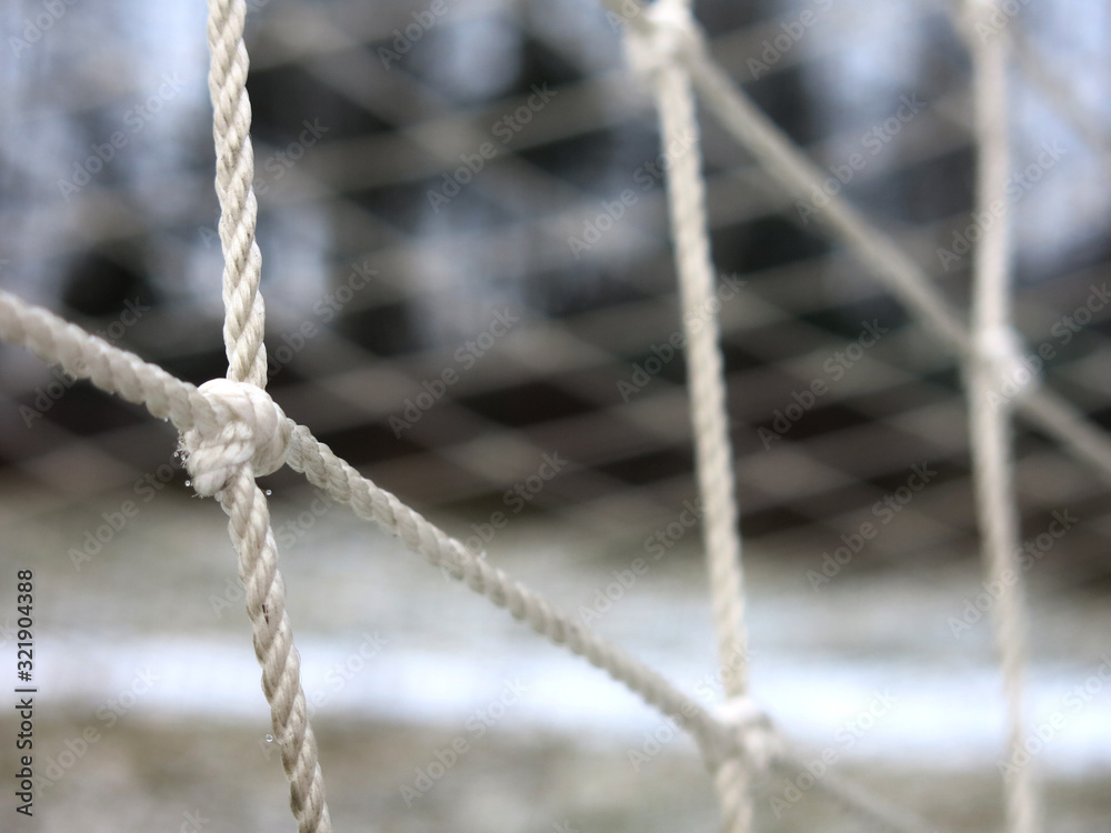 football goal with a grid close-up on a snow-covered sports field football goal with a grid close-up on a snow-covered sports field