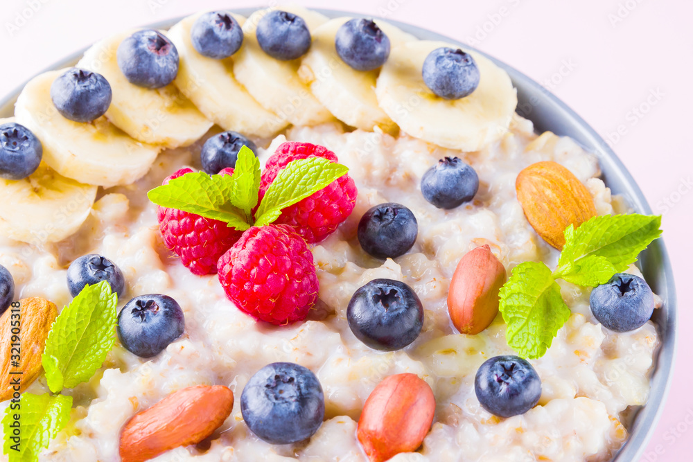Healthy breakfast. Bowl of oatmeal porridge with fresh blueberries, raspberries, almonds and banana. Clean eating, dieting, detox, vegetarian food concept. Healthy lifestyle concept Healthy breakfast. Bowl of oatmeal porridge with fresh blueberries, raspberries, almonds and banana. Clean eating, dieting, detox, vegetarian food concept. Healthy lifestyle concept