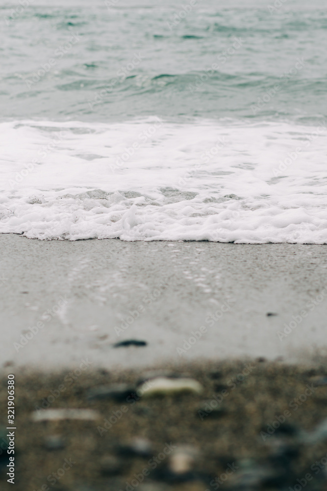 the sea wave arrives on the sandy shore . beautiful natural background the sea wave arrives on the sandy shore . beautiful natural background