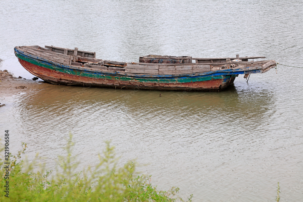 The broken fishing boat is in the river