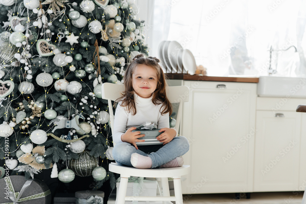 Fototapeta premium Happy little girl receives gifts. Holidays.