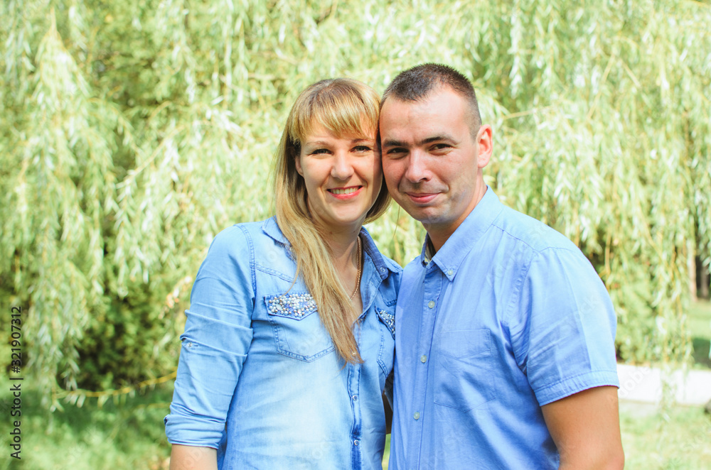 Obraz premium family shot in the park, summer day. .a guy with a girl dressed in a denim suit. very happy, cheerful and in love