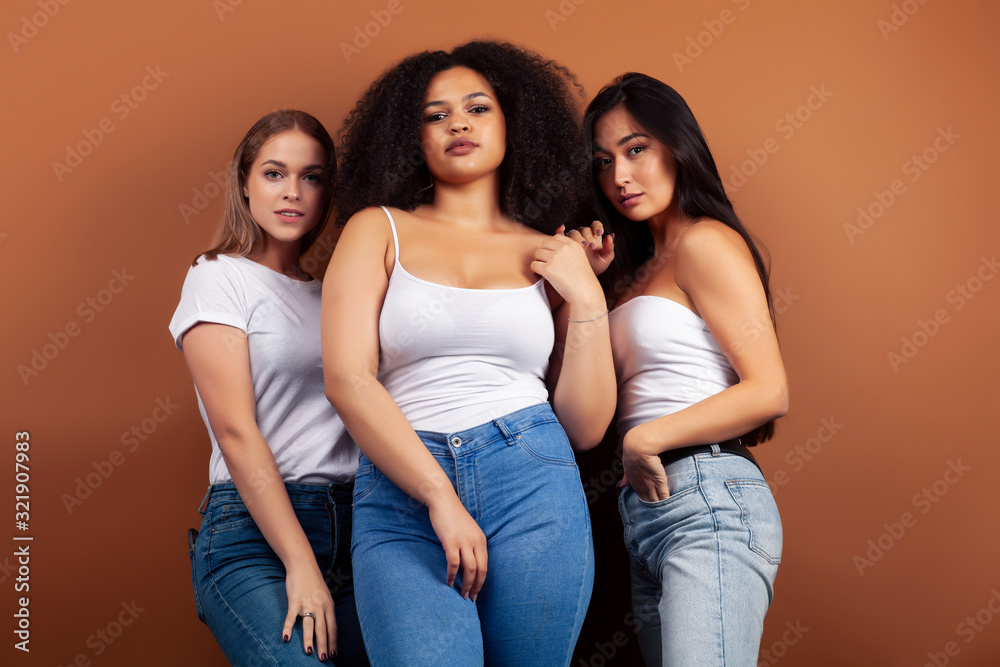 young pretty asian, caucasian, afro woman posing cheerful together on brown background, lifestyle diverse nationality people concept young pretty asian, caucasian, afro woman posing cheerful together on brown background, lifestyle diverse nationality people concept