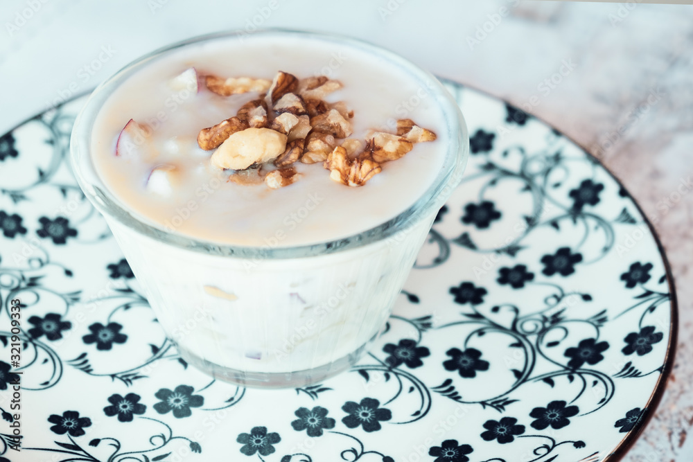 Albanian yogurt dessert with honey and walnuts nuts over white plate Albanian yogurt dessert with honey and walnuts nuts over white plate