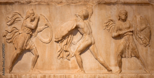 Ancient Greek marble bas-relief - Amazons with full military equipment fighting a Greek warrior. Athens, Greece
