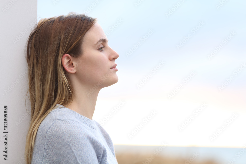 Serious melancholic woman looking away on the beach Serious melancholic woman looking away on the beach
