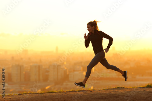 Jogger running in city outskirts at sunset