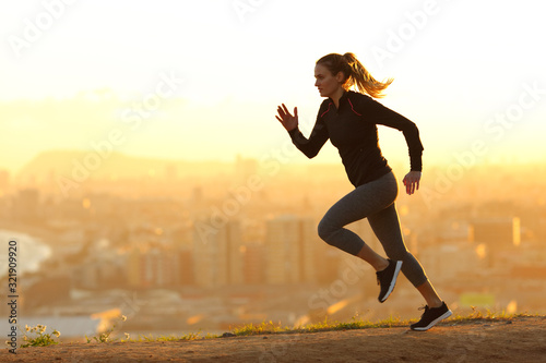 Runner woman running in the outskirts of the city photo