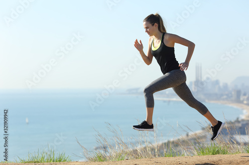 Runner woman running in city outskirts a sunny day
