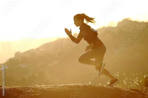 Runner woman running fast at sunset