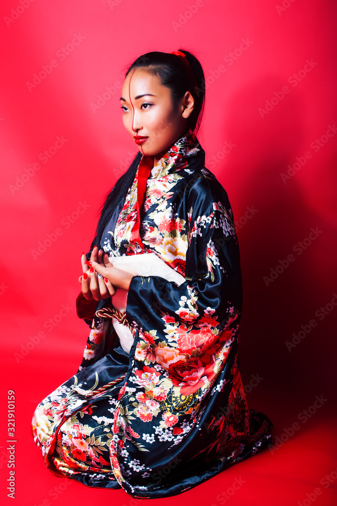 young pretty geisha on red background posing in kimono, oriental concept young pretty geisha on red background posing in kimono, oriental concept
