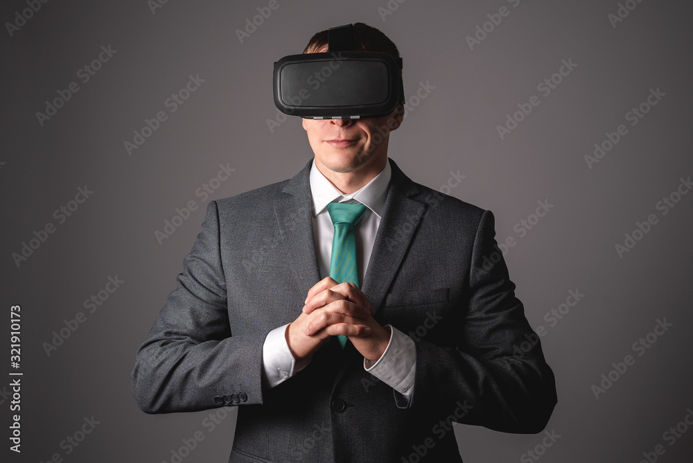 Businessman in virtual reality glasses on gray background. Businessman in virtual reality glasses on gray background.
