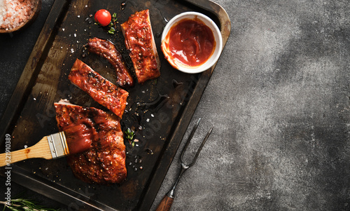 Delicious barbecued ribs seasoned with a spicy basting sauce and served on iron pan. photo