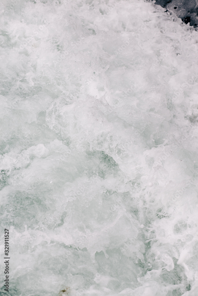Obraz premium seething sea foam from a wave that broke on a rock. natural sea background