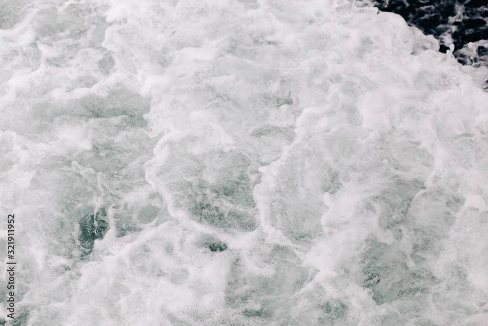 seething sea foam from a wave that broke on a rock. natural sea background seething sea foam from a wave that broke on a rock. natural sea background