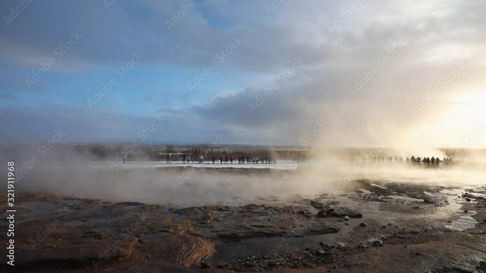 Slow motion tourists watching Geysir geyser Geothermal eruption in Iceland Slow motion tourists watching Geysir geyser Geothermal eruption in Iceland