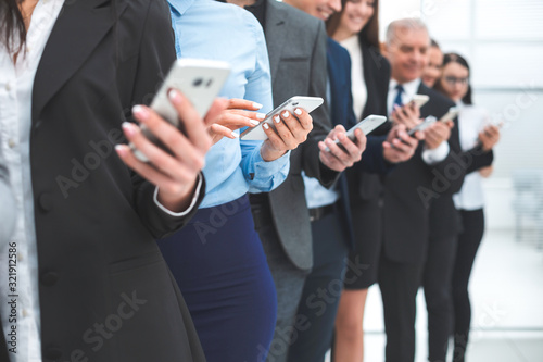 group of diverse employees with smartphones standing in a row