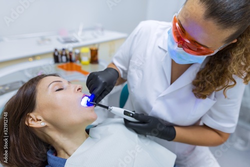 Patient sitting in dental chair  doctor dentist using professional medical equipment