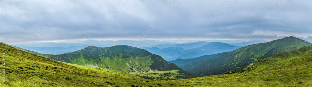 Panorama of beautiful, green mountains with clouds and forest. Ukraine, Carpathians.