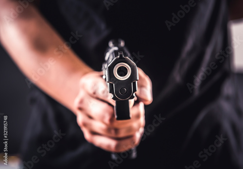 Canvas Print Killer with gun close-up pointing a gun at the target
