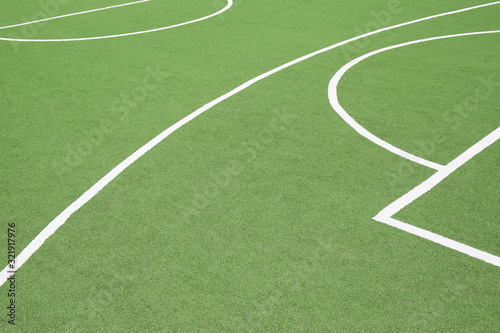 A green sports turf surface with white painted lines