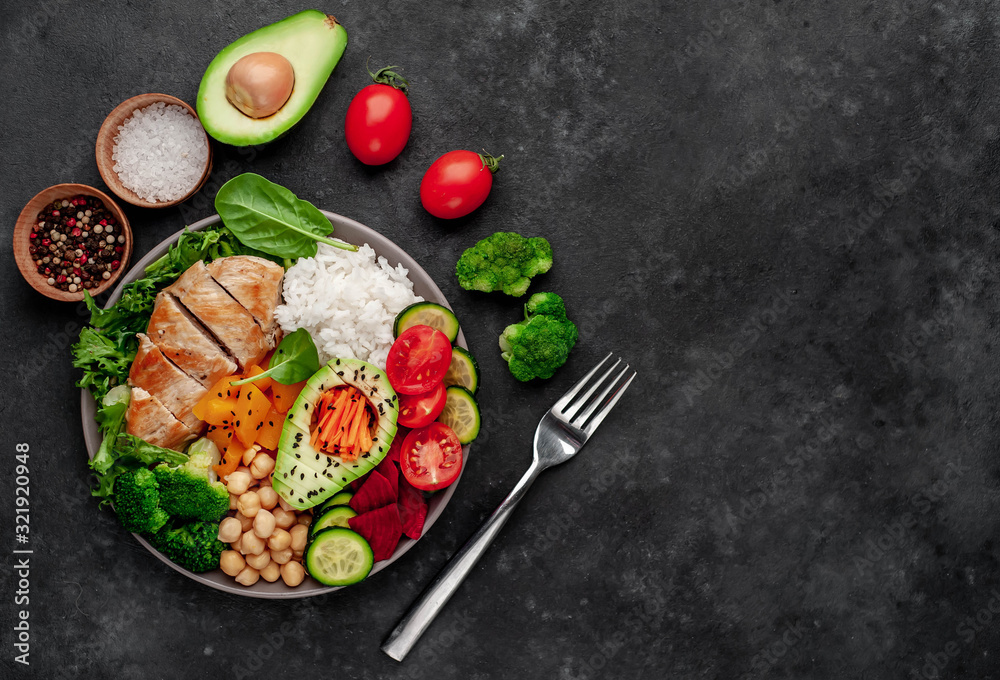 Bowl Buddha. rice, chicken breast, broccoli, pumpkin, avocado, chickpeas, carrots, cucumber, beets, a stone background  with copy space for your text
