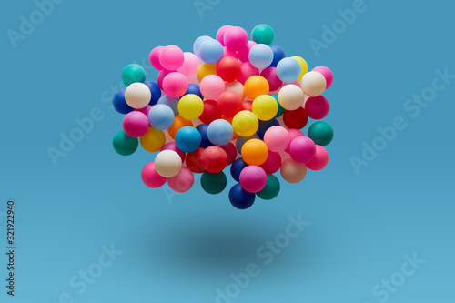 Colorful balls levitation in mid air on blue background