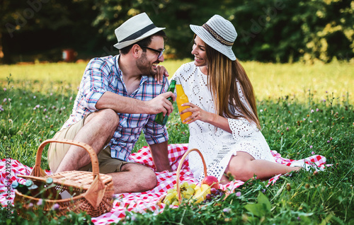 Happy couple enjoying picnic in the park. Love and tenderness, dating, romance, lifestyle concept