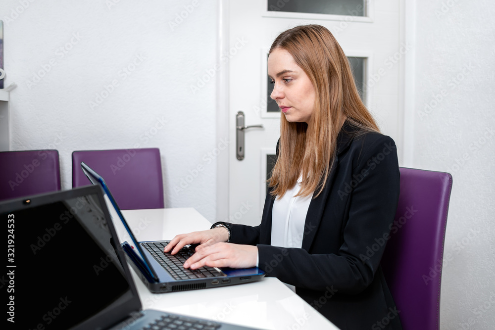 business woman working on laptop from profile business woman working on laptop from profile