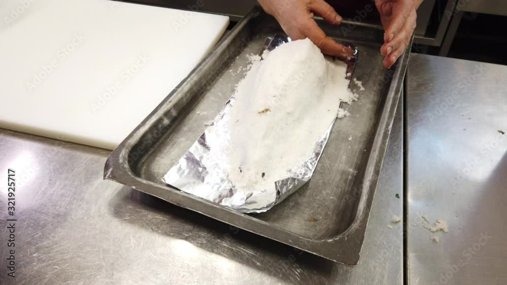 Chef preparing dorade fish in salt crust Chef preparing dorade fish in salt crust