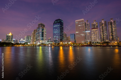 Scenic view of modern skyscrapers behind a lake at the Benjakiti (Benjakitti) Park in downtown Bangkok, Thailand, at dusk. © tuomaslehtinen