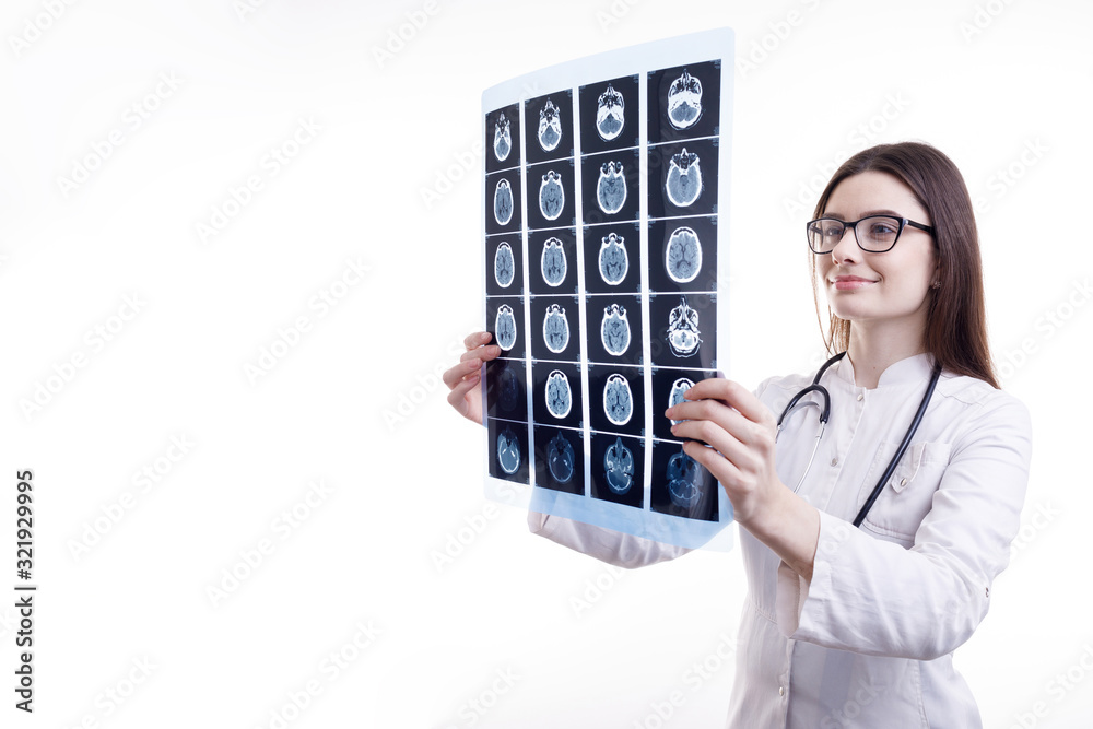 Smiling female MD is contented by what she sees on head tomography film isolated white background copyspace Smiling female MD is contented by what she sees on head tomography film isolated white background copyspace