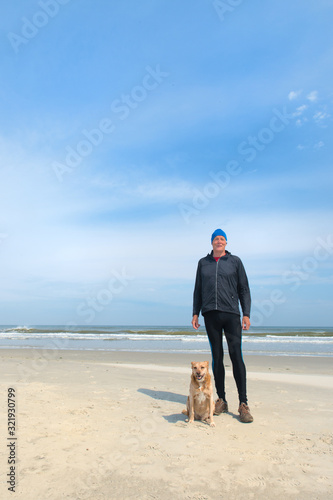 Senior man sporting with dog at beach