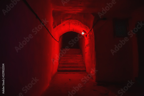 Staircase with steps in tunnel of underground military bunker with red light. photo
