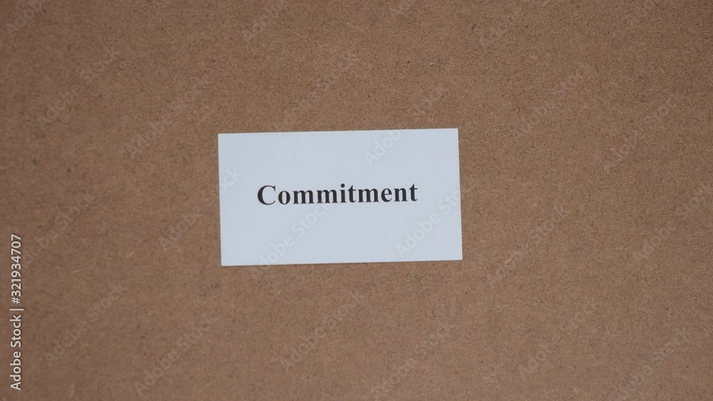 COMMITMENT. Top shot - Hand puts paper card with word. CORE VALUE concept. COMMITMENT. Top shot - Hand puts paper card with word. CORE VALUE concept.