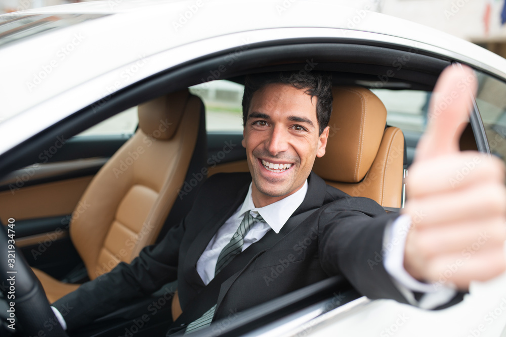 Happy man giving thumbs up while driving his car