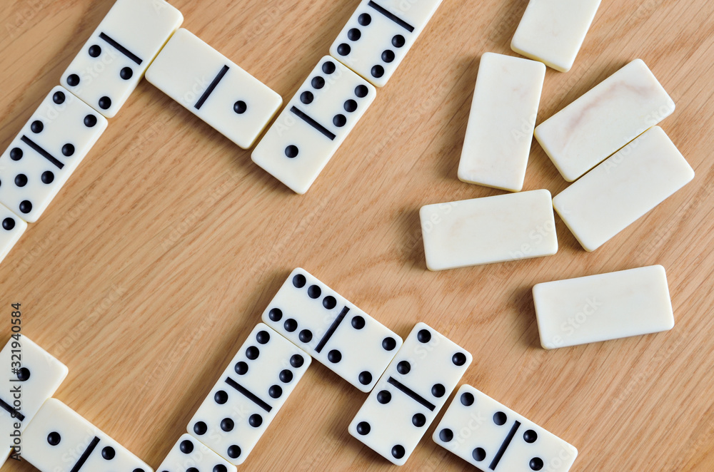 Playing dominoes on a wooden table. Dominoes game concept. Playing dominoes on a wooden table. Dominoes game concept.