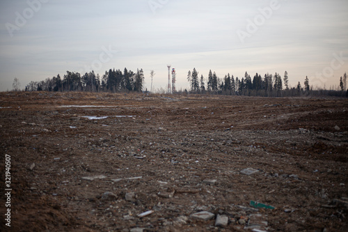 Wasteland after deforestation. Only one bare earth remained. The soil is plowed with heavy machinery. An earthen rampart on the edge of an industrial zone. 