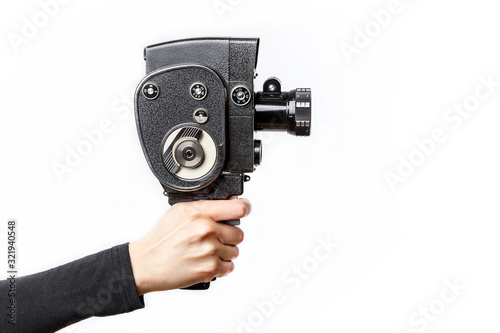 Female hand holding old style 8 mm movie camera on a white background
