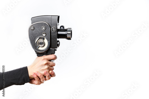 Female hand holding old style 8 mm movie camera on a white background