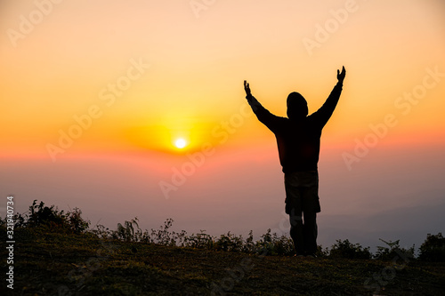 Silhouette of man praying in the sunrise