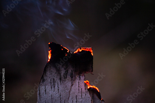 Fire in the dark. Birch bark burns. Breeding kotra at night. Background flame of a burning tree. photo